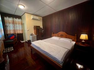 a bedroom with a large bed with a wooden wall at Ban Heng in Phra Nakhon Si Ayutthaya