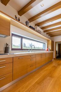 uma cozinha com armários de madeira e uma grande janela em Black Swan em Brocēni