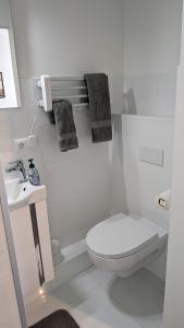 a white bathroom with a toilet and a sink at Deine Unterkunft in zentraler Lage in Hamburg Altona in Hamburg