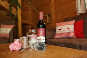uma garrafa de vinho sentada numa mesa com copos em Blockhaus 1 em Steina