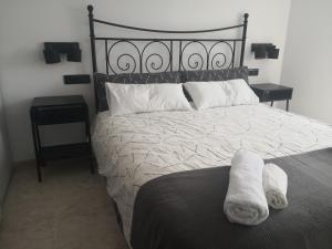 a bed with a white towel laying on it at O RECUNCHO DE MORA in Ribeira