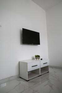 un meuble blanc avec une télévision murale dans l'établissement Apartments and Rooms La Vida, à Konjic