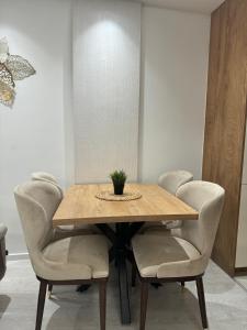 a dining room table with chairs and a potted plant on it at Luxury apartment Old town Novi Pazar in Novi Pazar