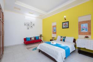 a bedroom with a bed and a yellow wall at Villa Hồ Bơi 47 - Gần Biển Bãi Sau - Phòng Khách Có Máy Lạnh in Vung Tau