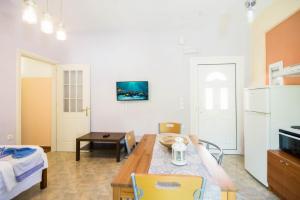 ein Wohnzimmer mit einem Esstisch und einer Küche in der Unterkunft Scorpios Apartments in Dassia