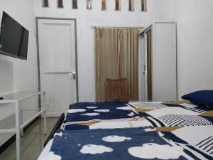 - une chambre avec 2 lits avec des draps bleus et blancs dans l'établissement Hotel Residence 5 Syariah, à Bandung