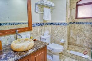 a bathroom with a toilet and a sink at Acanto Hotel Playa del Carmen, Trademark Collection by Wyndham in Playa del Carmen +218 photos