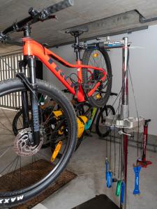 - un vélo orange sur un porte-vélos dans un garage dans l'établissement LUMEN ALBERGUE, à Mondoñedo