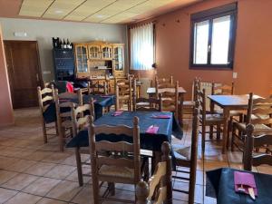 a dining room with tables and chairs and a kitchen at Hotel El Cid in Torres de Albarracín