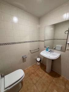 y baño con aseo y lavamanos. en Hotel El Cid, en Torres de Albarracín