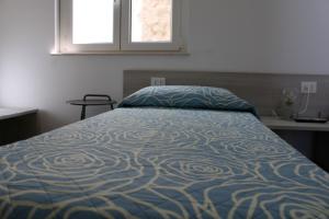 カルタニッセッタにあるLa Dimora di Don Salvatoreのベッドルーム1室(青い掛け布団、窓付)