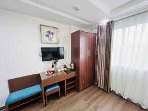 Habitación de hotel con escritorio y TV en Khách Sạn 239, en Hanói