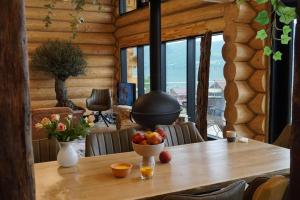 a wooden table with a bowl of fruit on it at Cabana de Bușteni in Eşelniţa