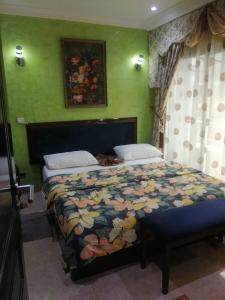 a bedroom with a bed with a colorful comforter at Hôtel LE PÉRIDOT in Brazzaville