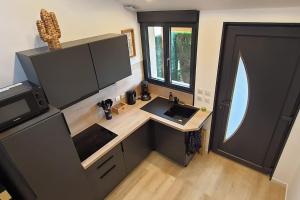 a kitchen with a desk and a sink in a tiny house at Gîte des Côtes de Vezon in Marieulles