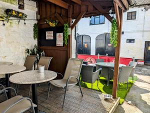 Graham Arms Inn في Longtown: فناء به طاولات وكراسي في مطعم