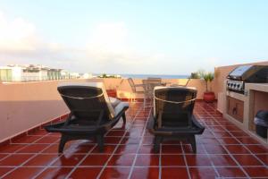 a balcony with two chairs and a stove at Acanto Hotel Playa del Carmen, Trademark Collection by Wyndham in Playa del Carmen