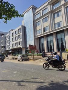 a man riding a motorcycle down the street at Hotel Nand Residency in Ghāzīpur