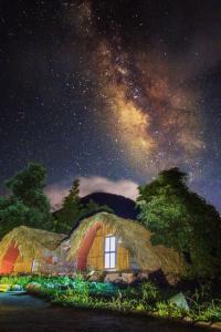 ein Haus mit Strohdach unter einem Sternenhimmel in der Unterkunft Nhà Tổ Ong in Lai Châu