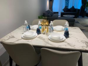 a marble table with plates and bottles of water on it at Eaton Residences KLCC by Ikon in Kuala Lumpur