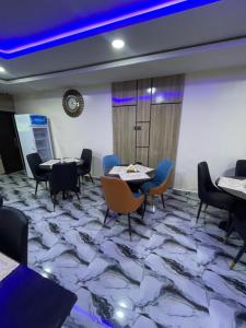 una sala de reuniones con mesas y sillas en un suelo de mármol en Masters Class Hotels and Apartment, en Uyo