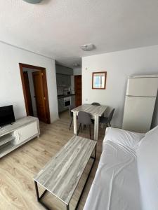 a living room with a table and a bed at Service Apart Lazaro- Apartamentos Aguamarina 14 in Calpe