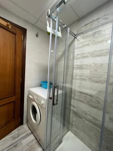 a washing machine in a bathroom with a shower at Service Apart Lazaro- Apartamentos Aguamarina 14 in Calpe