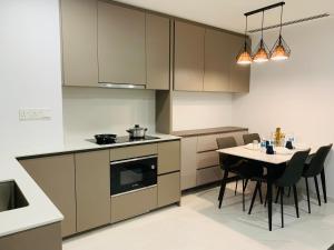a kitchen with a table and a stove and cabinets at Eaton Residences KLCC by Ikon in Kuala Lumpur