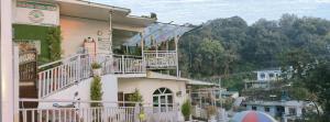 a white building with a balcony on top of it at Golden Oak Villa in Mussoorie