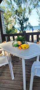 a white table with fruits and vegetables on a deck at Camping Ancora in Comacchio