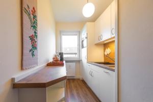 una cucina con mobili bianchi e un piano di lavoro in legno di Chiemgau Comfort C6 Ferienwohnanlage Oberaudorf mit Hallenbad und Sauna a Oberaudorf