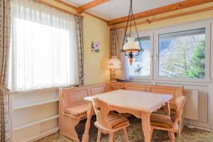 una sala da pranzo con tavolo, sedie e una finestra di Chiemgau Comfort C6 Ferienwohnanlage Oberaudorf mit Hallenbad und Sauna a Oberaudorf