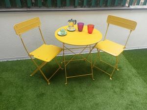 a yellow table and two chairs with drinks on it at Alla marina in Fiumefreddo di Sicilia +1 photo
