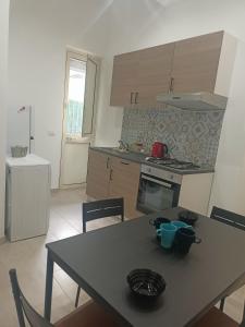 a kitchen with a table and chairs and a table and a stove at Alla marina in Fiumefreddo di Sicilia