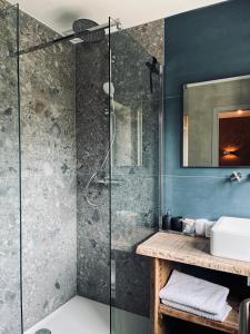 uma casa de banho com um chuveiro e um lavatório. em La Grainerie em Durbuy