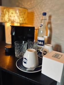 einen Tisch mit zwei Tassen Kaffee und einer Flasche Soda in der Unterkunft La Grainerie in Durbuy