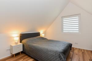 una camera da letto con un letto e una finestra di DREAM HOUSE PALANGA WITH PRIVATE SWIMMING POOL, Hot Tub and Sauna a Palanga Altre 56 foto