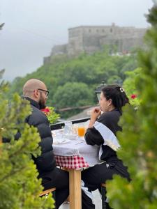 un hombre y una mujer sentados en una mesa en Castle Hotel en Gjirokastër