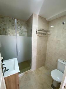 Un baño con ducha, inodoro y lavabo. en La ilusión de Pepa, en El Puerto de Santa María