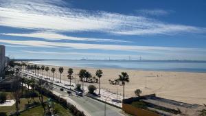vistas a una playa con palmeras y a una carretera en La ilusión de Pepa, en El Puerto de Santa María