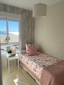 Un dormitorio con una cama y vistas a la playa. en La ilusión de Pepa, en El Puerto de Santa María