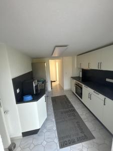 a kitchen with white cabinets and black counter tops at Unterm-Felsen in Bad Überkingen