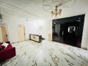a living room with a large marble floor and a chandelier at Hotel MK Lawn in Bareilly