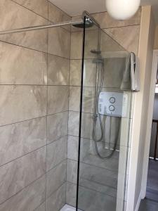 La salle de bains est pourvue d'une douche avec une porte en verre. dans l'établissement Temple Loft Studio, à Moate