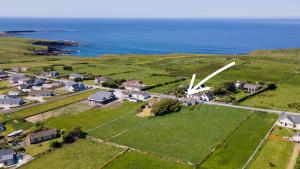 una vista aérea de una pequeña localidad con un molino de viento en Ard Na Mara, Mullaghmore, Sligo, en Mullaghmore