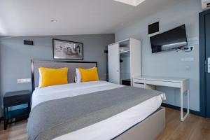a bedroom with a large bed with yellow pillows at The Row Taksim Hotel in Istanbul