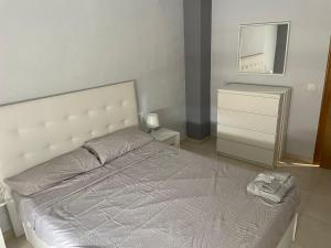 sypialnia z łóżkiem, komodą i lustrem w obiekcie APARTAMENTO CERCANO AL CENTRO w Walencji