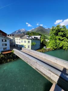 eine Brücke über den Fluss in einer Stadt in der Unterkunft Spacious cellar studio surrounded by mountains and lake in Schwändi