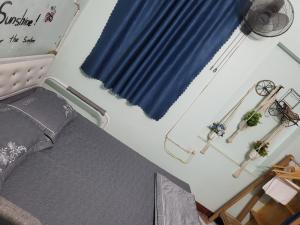 1 dormitorio con cama y cortina azul en Golden Bell Backpacker Hostel, en Ninh Binh