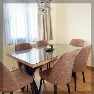 a dining room table with chairs and a bowl of fruit on it at Favelas Luxury Apartments in Kavála